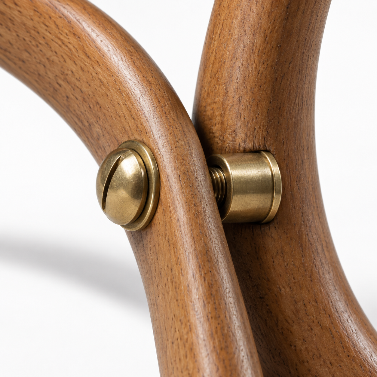 Close-up of a brass screw and nut joining two curved wood pieces